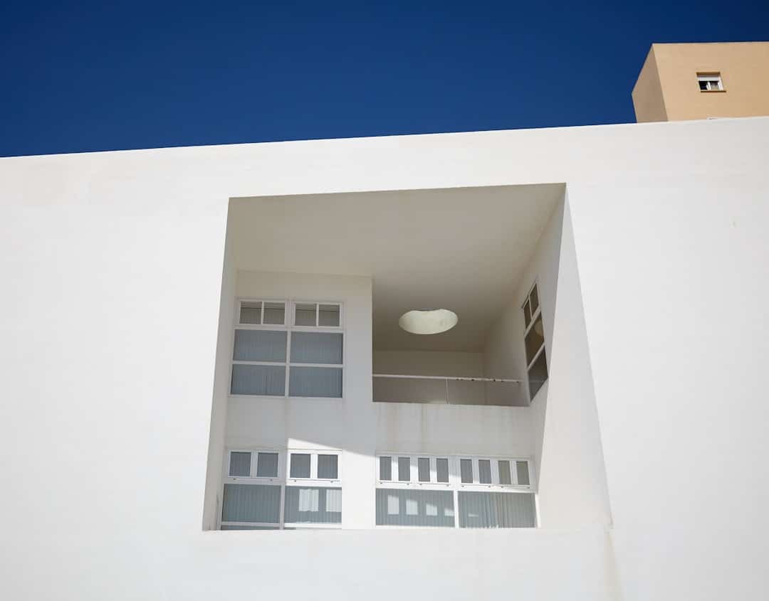 The bright, sunny exterior of a modern minimalist house with clean lines, representing a successful and streamlined real estate franchise model.