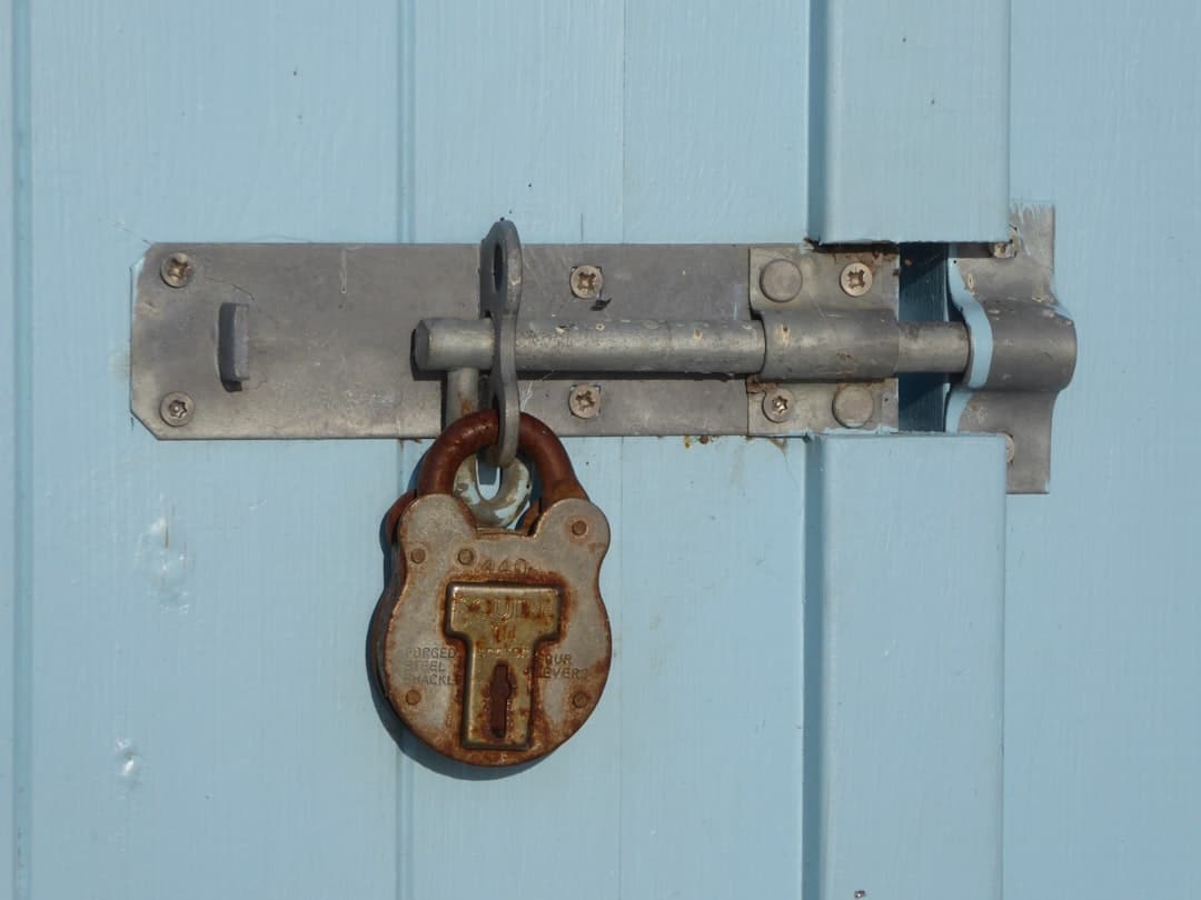 A close-up of a person's hand holding a single, modern key with the blurred background of a contemporary commercial building, representing a new business opportunity.