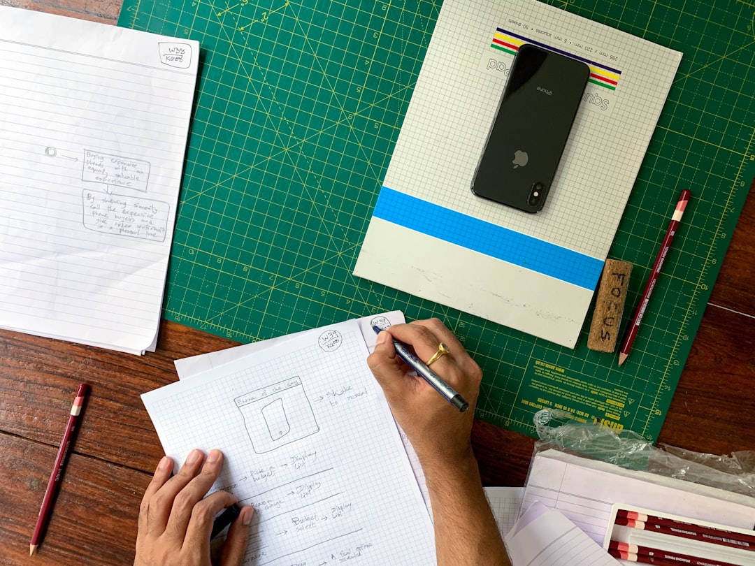 Two professionals in a bright, modern setting lean over a table, collaboratively reviewing architectural blueprints, symbolizing the planning of a new business asset.