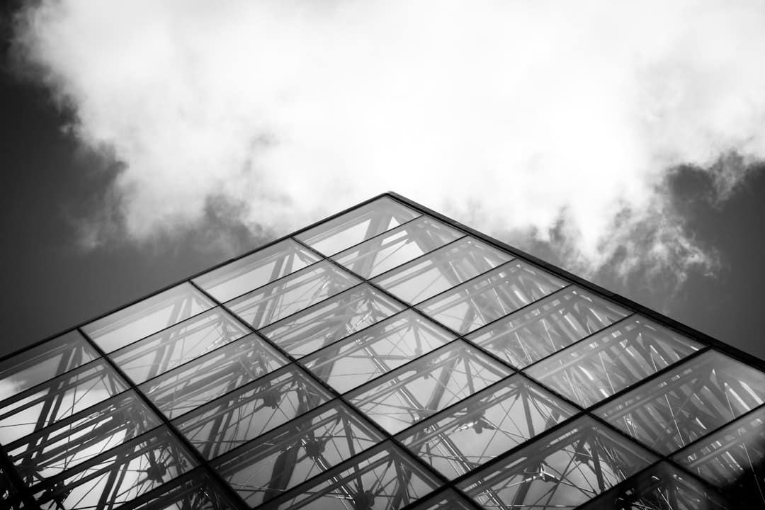 An upward-looking shot of a sleek, modern glass building against a bright, clear sky, representing a future-proof and successful new financial model.