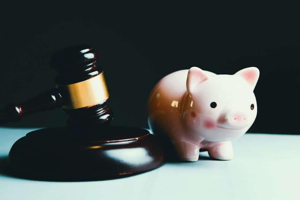 Minimalist photo of a broken piggy bank on a clean background, with coins spilling out, symbolizing the deconstruction of ...