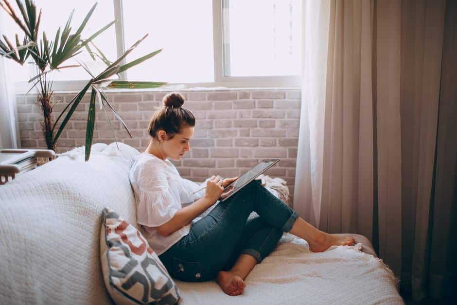 A professionally dressed real estate agent using a tablet inside a bright, modern home, showcasing the use of technology in a lean franchise system.